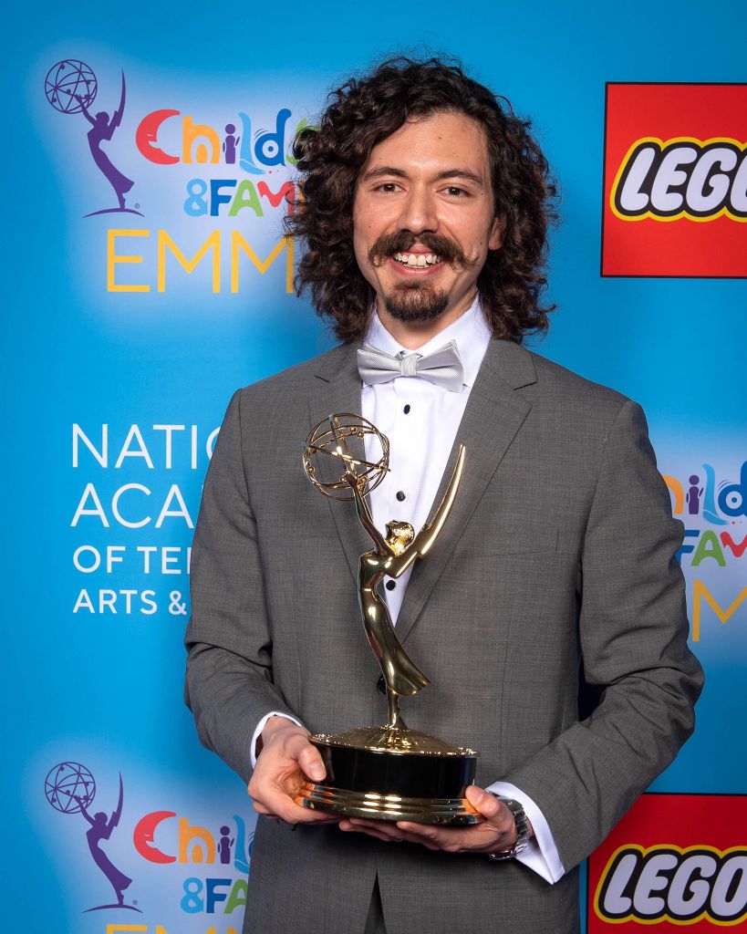 Andrés Locsey holding an Emmy award.